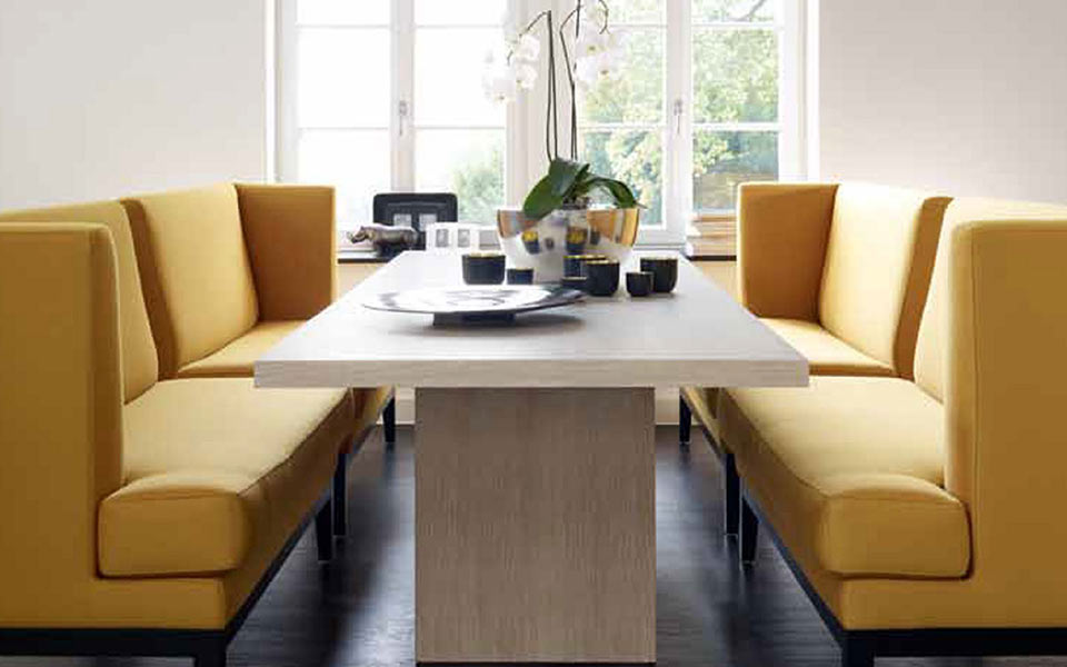Gelbe Sofas neben einem hellen Holztisch