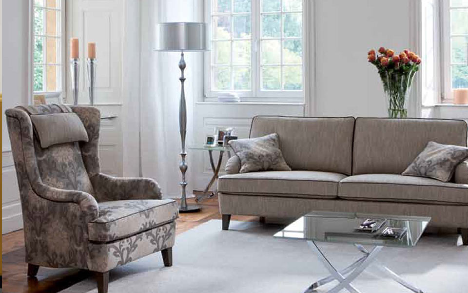 Graues Sofa und gemusterter Hocker im klassichen Stil