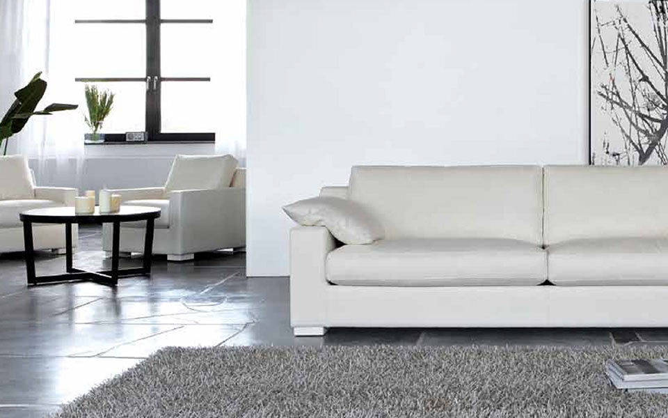 Weißes Sofa mit zwei weißen Sesseln im Wohnzimmer