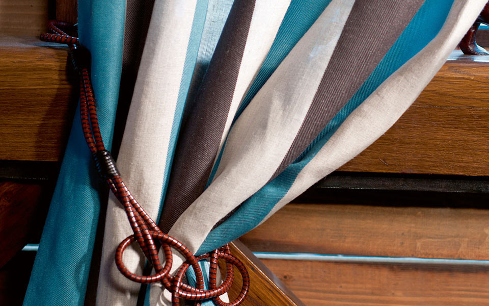 Festgebundener Vorhang mit weißen, blauen und schwarzen Streifen