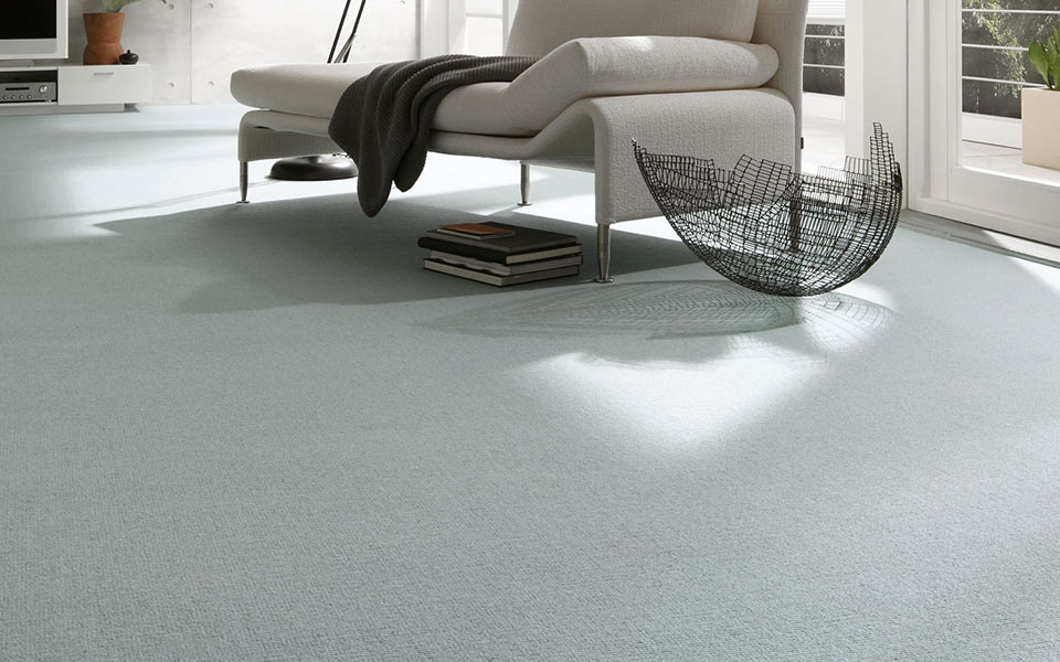 Blaugrauer Teppich mit verschiedenen Möbelstücken
