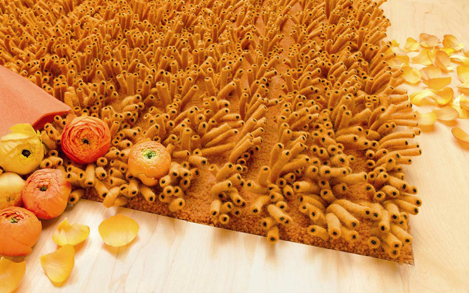 Oranger Hochflor Teppich mit Dekoblüten