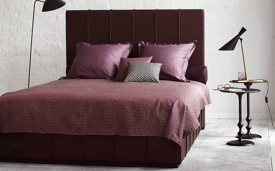 Rotes Doppelbett mit gleichfarbiger Wäsche und Kissen
