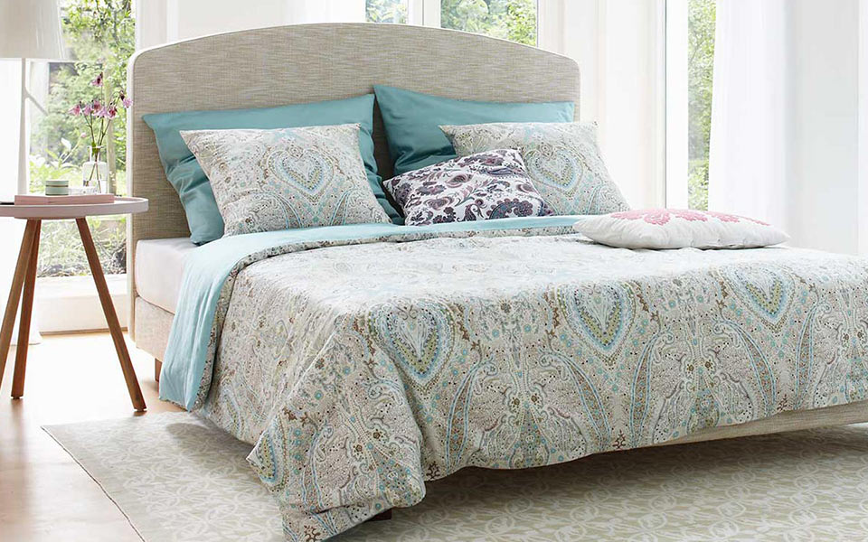 Großes Doppelbett mit gemusterter Bettwäsche