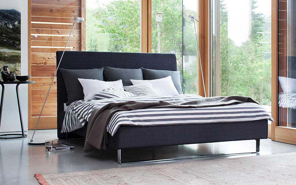 Schwarzes Bett mit schwarz-weißem Bettbezug