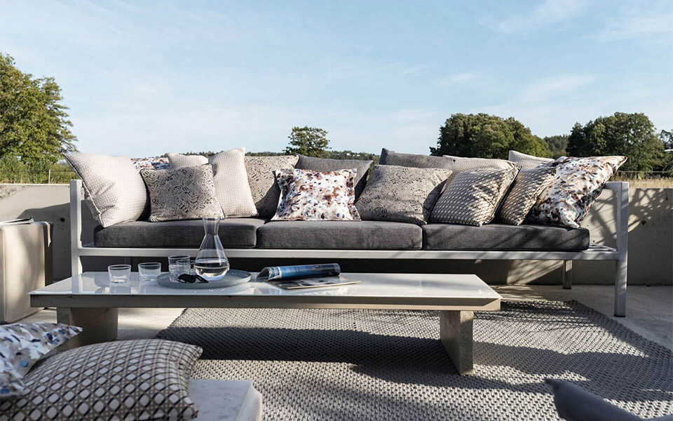 Designersofa im Outdoorbereich mit Kissen